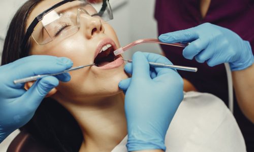 Beautiful girl in a dentist The dentist treats the girl's teeth. A young woman visited a dentist. The doctor works with an assistant